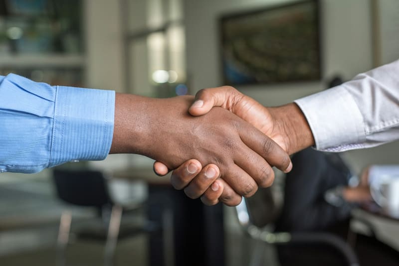 Two people shaking hands across a table